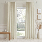 Beige cotton-linen curtain panels with vertical pleats hanging from a rod