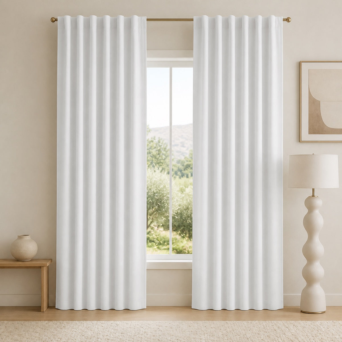 White blackout curtains with vertical pleats and metal grommets, hanging in front of a window.