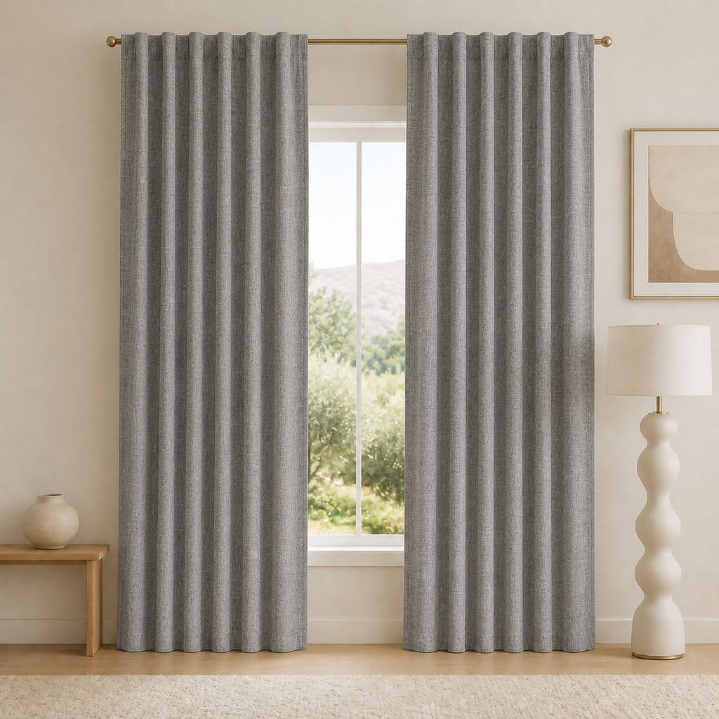 Dark gray blackout curtains with deep vertical pleats and metal grommet header, centered.