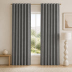 Dark gray blackout curtains with vertical pleats and grommets, shown from a straight-on angle.