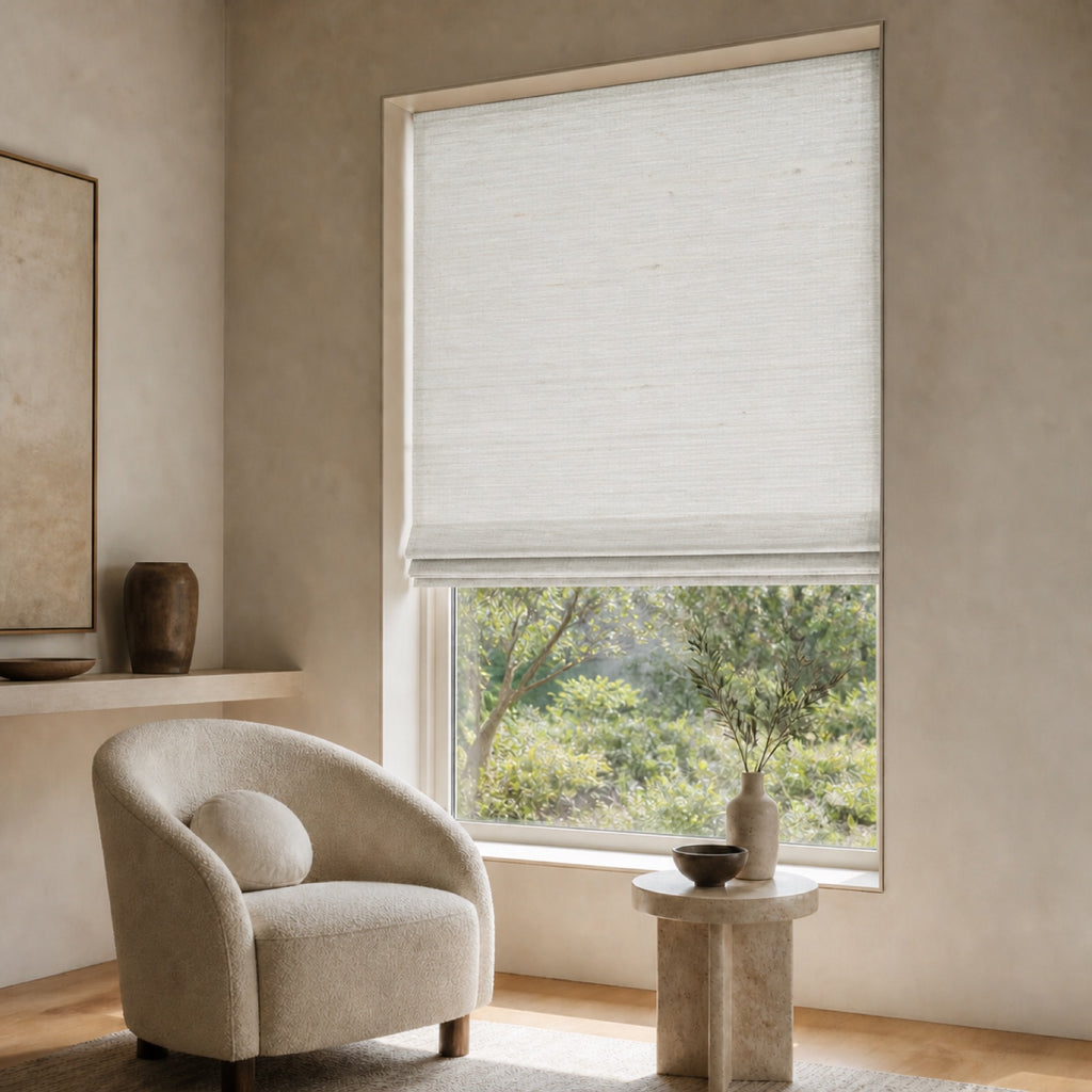 Very light woven bamboo roller shade with airy texture, partially lowered over a window.
