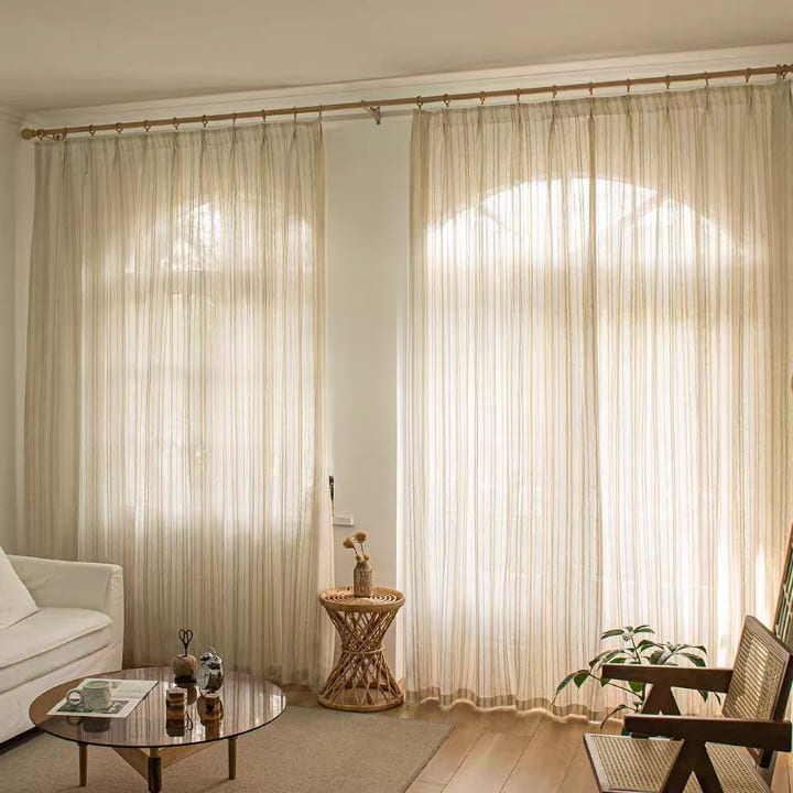 Linen-blend sheer curtains with vertical stripe pattern, gathered at a top rod pocket.