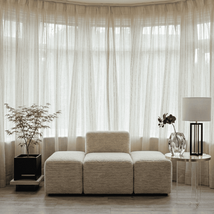 Sheer vertical stripe curtains with gathered top, flowing drape with soft texture.