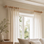 Light beech solid wood curtain rod with circular finials and wall-mounted bracket